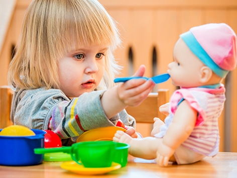 https://tulamama.com/wp-content/uploads/2018/08/learning-toys-for-toddlers-feeding-baby.jpg